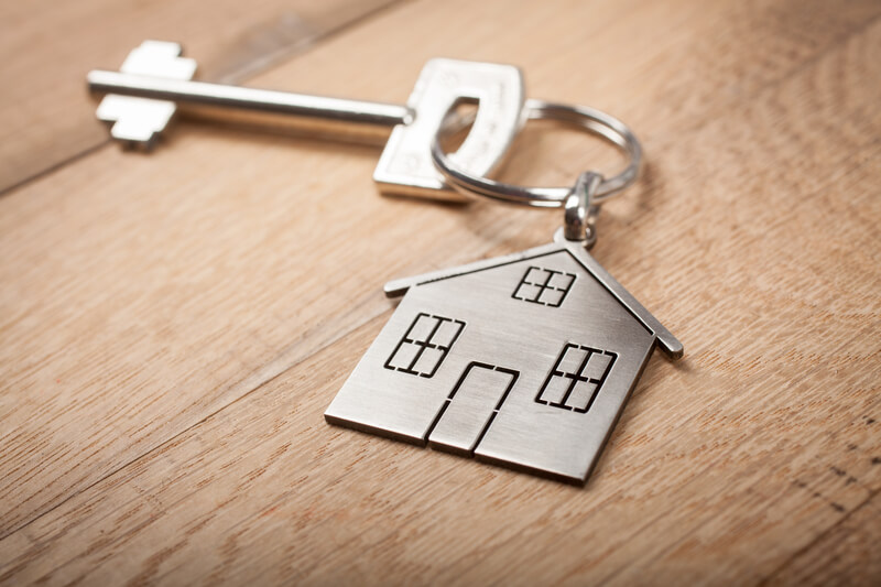 A imagem mostra um chave com um chaveiro no formato de uma casa. Foto para ilustrar o artigo sobre comprar ou alugar imóvel
